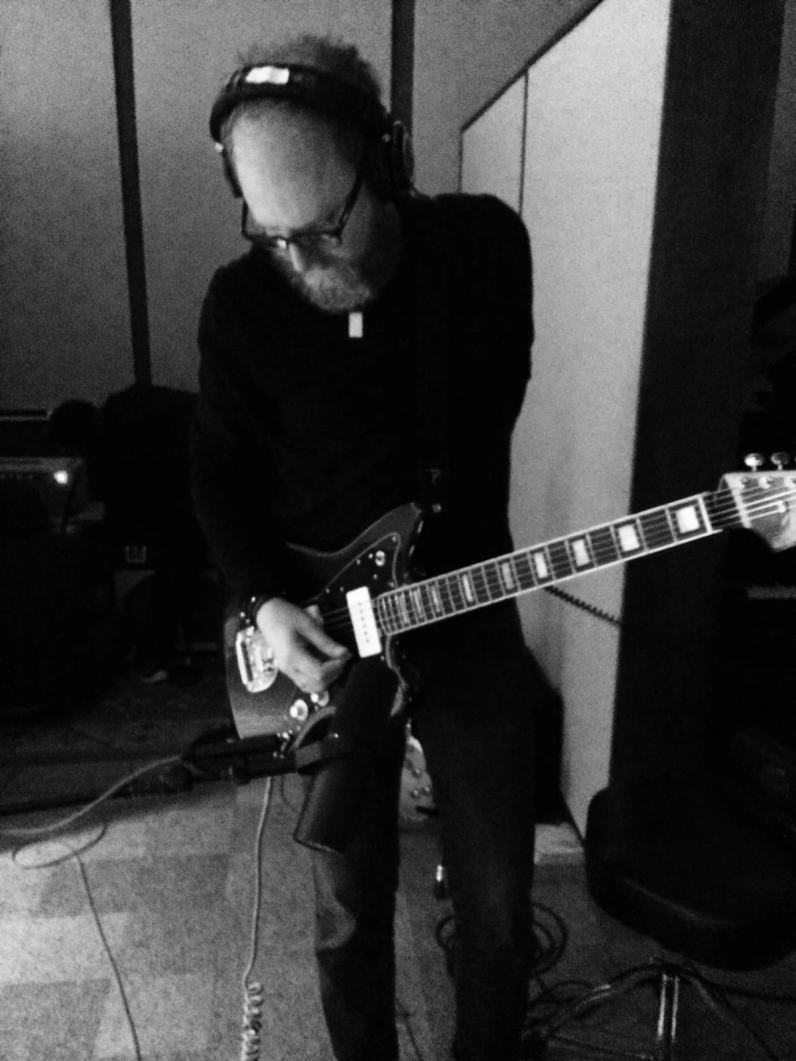 Eric Jarvis playing guitar in a recording room