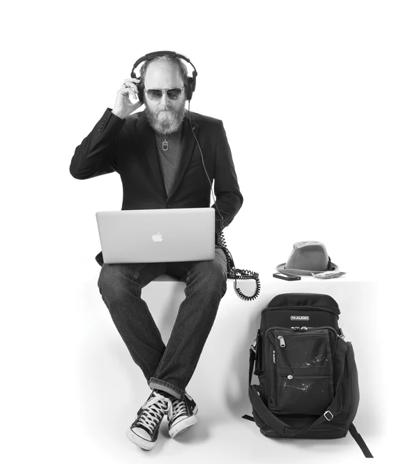 Eric Jarvis wearing headphones and working at a laptop